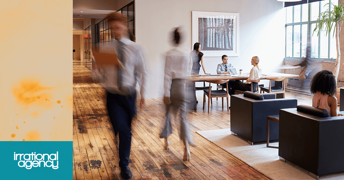 Employees seated at a table while others walk passed